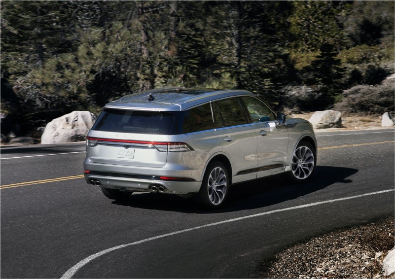 A 2023 Lincoln Aviator® Grand Touring model is shown being driven on a tight turn of a mountain road | Casa Lincoln in El Paso TX