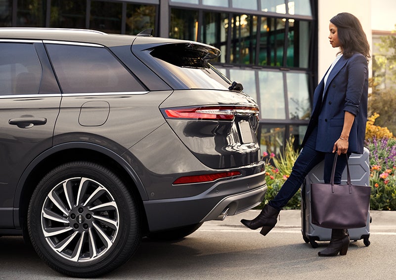 A woman with her hands full uses her foot to activate the available hands-free liftgate. | Casa Lincoln in El Paso TX