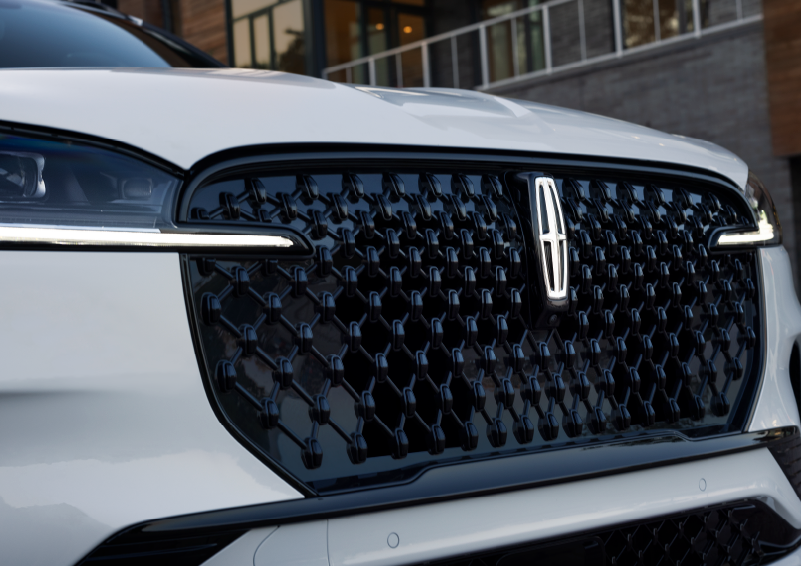 The black grille of a white 2025 Lincoln Aviator® SUV is shown with its fog lights on. | Casa Lincoln in El Paso TX