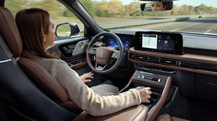 A woman is seen sitting in the driver’s seat of her 2025 Lincoln Aviator® SUV with her hands off the steering wheel. | Casa Lincoln in El Paso TX