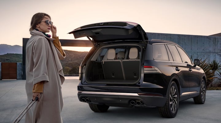 A woman approaches a 2026 Lincoln Aviator® SUV with its rear liftgate open. | Casa Lincoln in El Paso TX