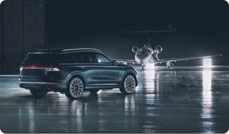 A Blue Lincoln SUV parked at a hanger